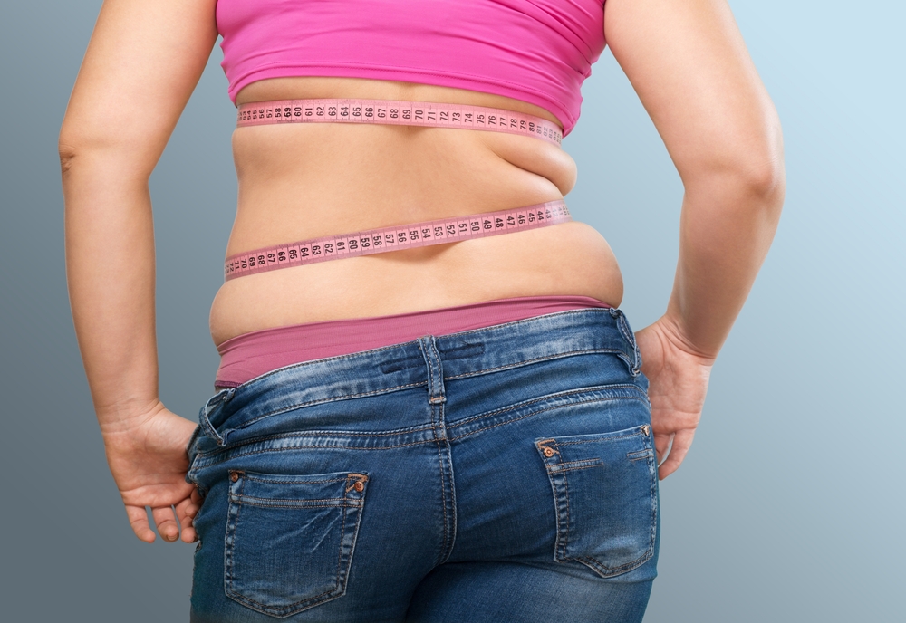 A woman's torso with a measuring tape to represent weightloss