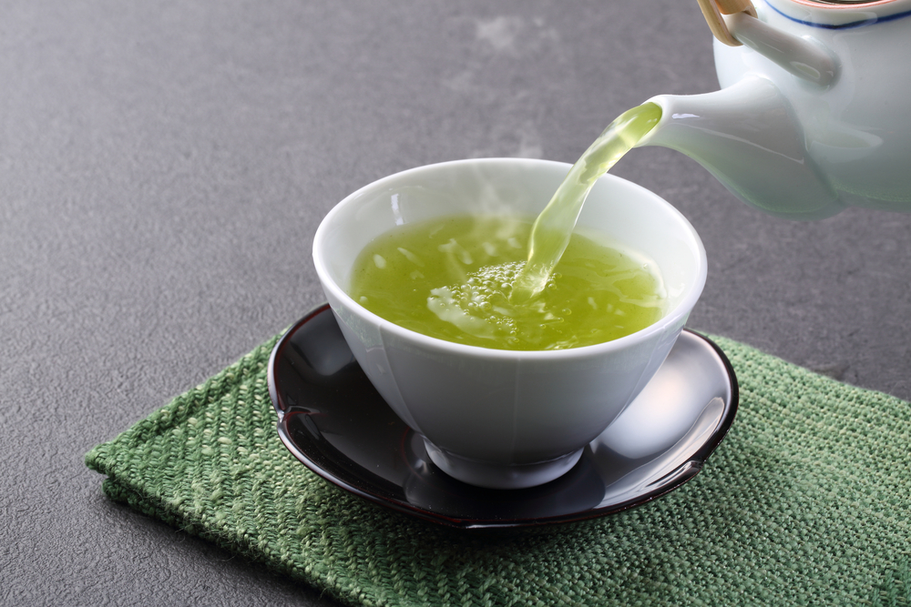 Close up of green tea being poured into a cup