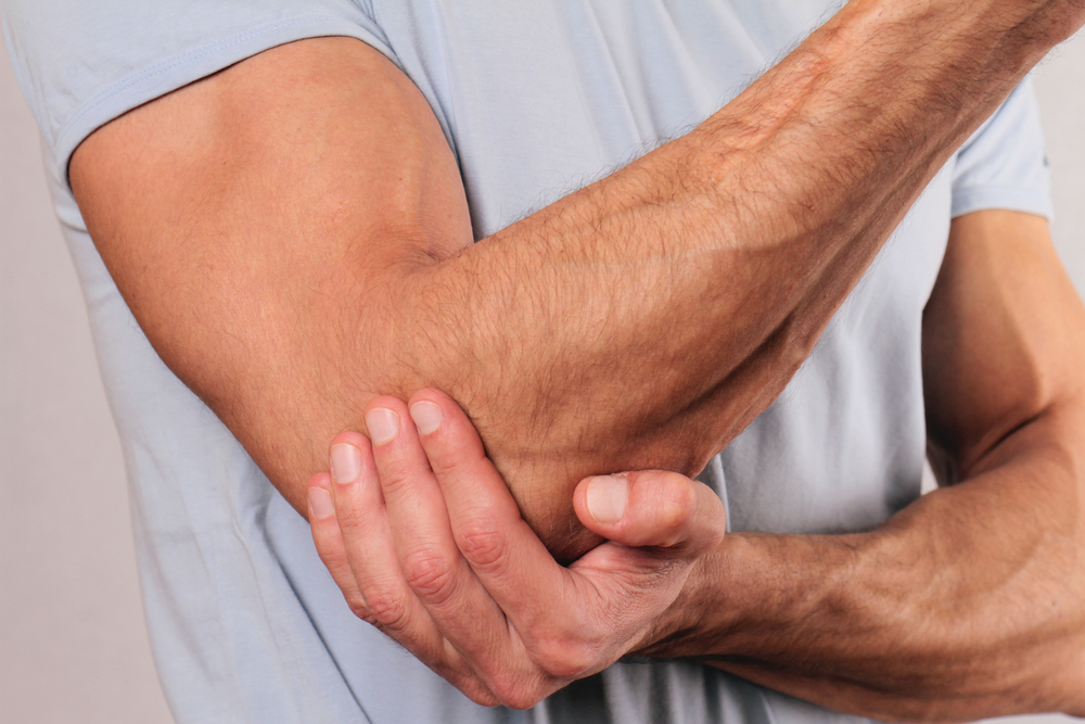 Close up of man holding his elbow suffernig with arthritis