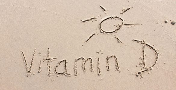 Vitamin D and a sunshine written into the sand on beach