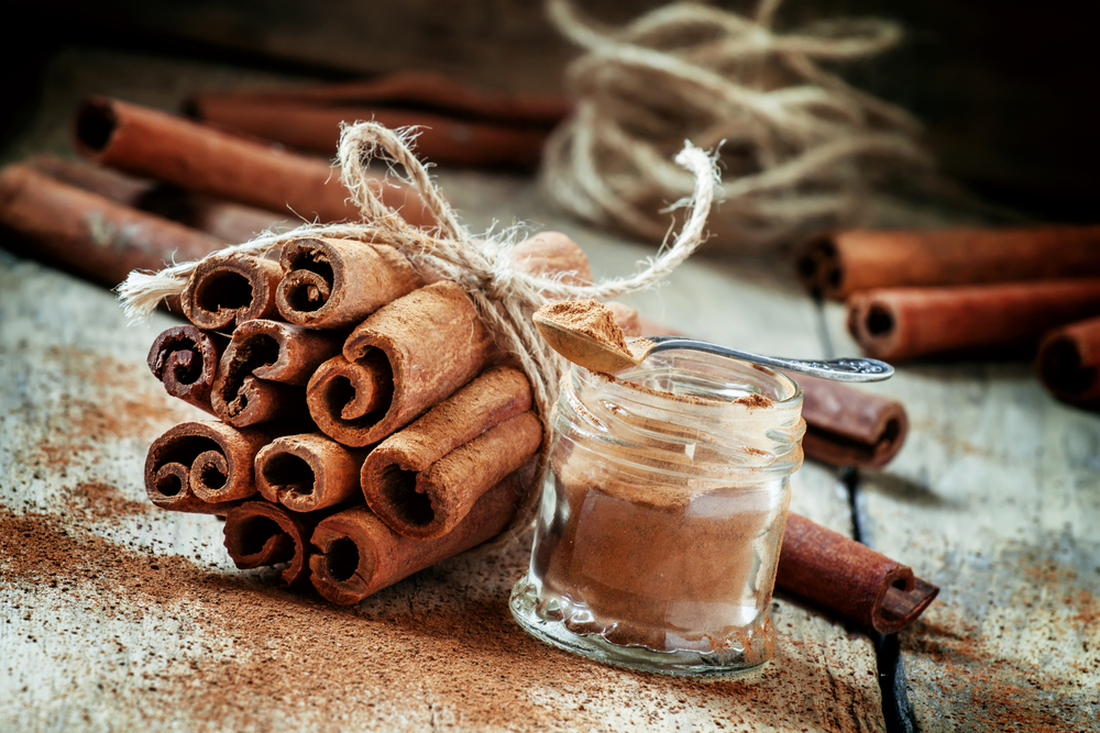 A pot of ground cinnamon and cinnamon sticks