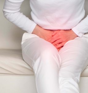 Woman resting hands over groin area depicting bladder incontinence