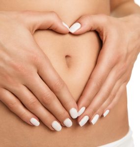 Close up on stomach with hands making a heart shape to show good digestion