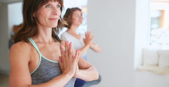 Woman doing yoga standing with hands in prayer position