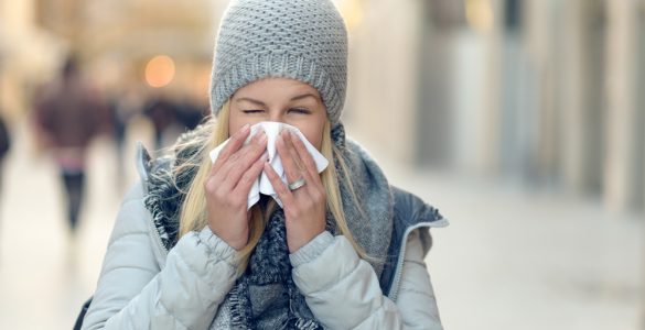 Woman with cold blowing her nose