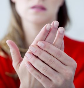 Close up of woman with painful hands due to Raynaud's syndrome