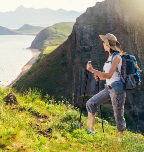 A woman hiking outdoors overlooking a sea cliff