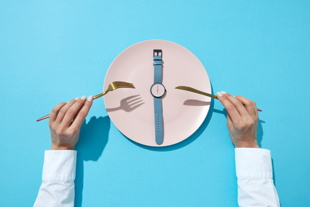A dinner plate wiht a watch on saying 6 o'clock