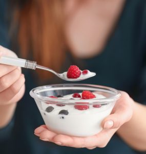 Close up of a woman wating yoghurt with fruit