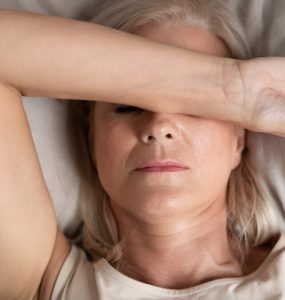 Close up of middle aged woman in bed struggling to sleep