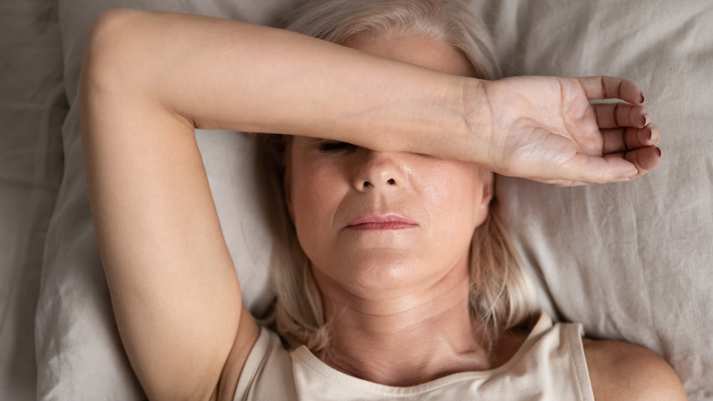 Close up of middle aged woman in bed struggling to sleep