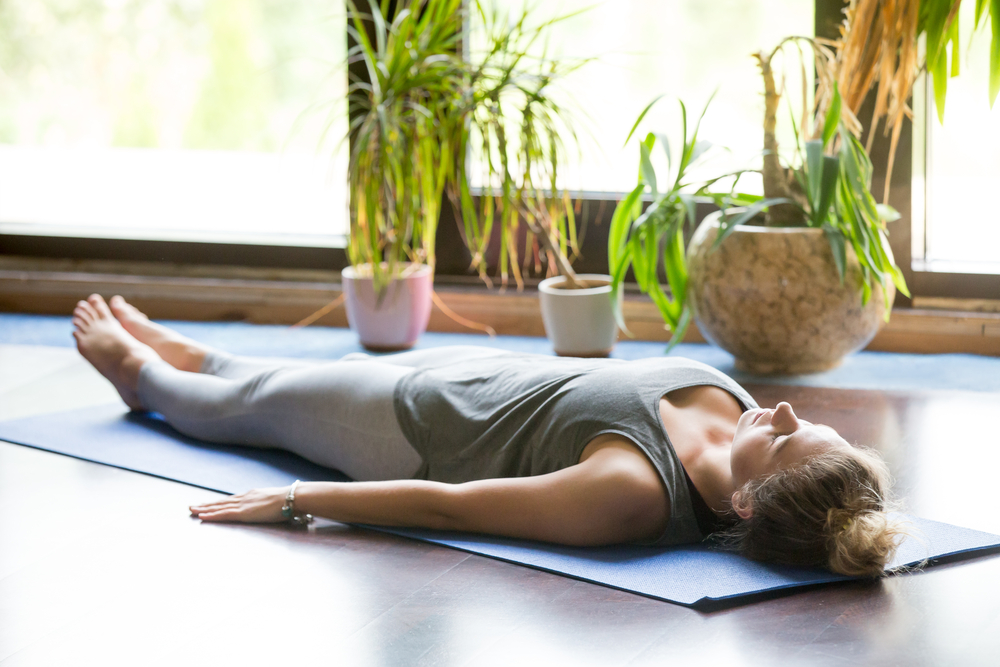 A woman relaxing on a yoga mat